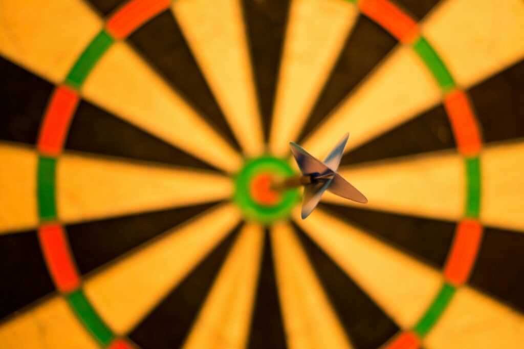 A close-up of a dart perfectly hitting the bullseye on a dartboard, symbolizing accuracy.